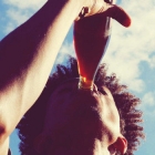Low Angle View Of Man Drinking Cola Against Sky
